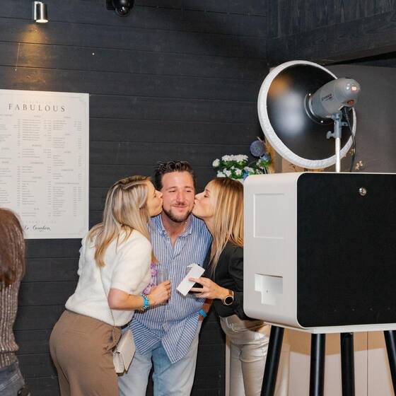 Koppel geeft een kus bij de photobooth