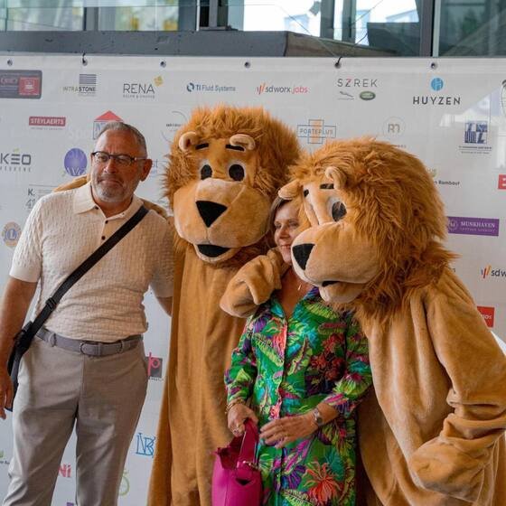 Gast met twee leeuwenmascottes op een bedrijfsevent