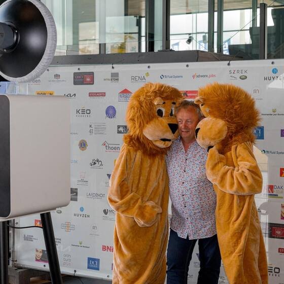 Gast tussen de twee leeuwenmascottes
