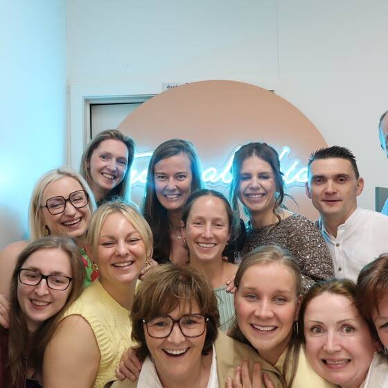 Grote groep collega's voor de fotowand